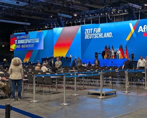 AfD-Parteitag in Erfurt: Delegierte diskutieren Satzungsänderungen, friedliche Proteste im Hintergrund.
