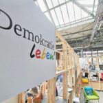 Messestand der Initiative "Demokratie leben" mit Informationen zur zivilgesellschaftlichen Förderung und Engagement.
