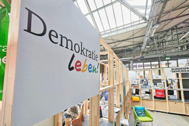 Messestand der Initiative "Demokratie leben" mit Informationen zur zivilgesellschaftlichen Förderung und Engagement.