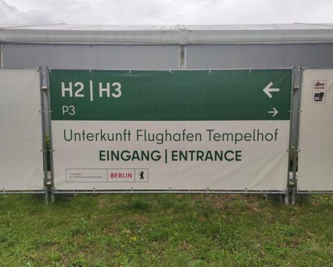 Flüchtlingsunterkunft mit Menschen, symbolisiert den Rückgang der Asylanträge in Deutschland 2026.