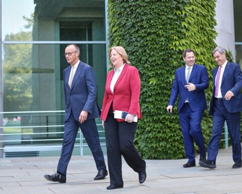 Pressekonferenz mit Politikern, die kritisch über das 34-Punkte-Paket diskutieren. Spannung und Besorgnis sichtbar.