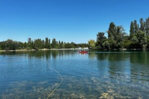 Feuerwehr- und Rettungskräfte suchen mit Rettungsschwimmern und Tauchern nach einer vermissten Person im Wasser.