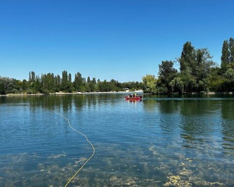 Feuerwehr- und Rettungskräfte suchen mit Rettungsschwimmern und Tauchern nach einer vermissten Person im Wasser.