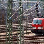 Deutsche Bahn-Lokomotive auf Gleisanlage (Archivfoto), während über Gewinn und Passagierrekord berichtet wird.