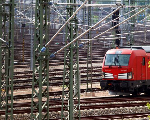 Deutsche Bahn-Lokomotive auf Gleisanlage (Archivfoto), während über Gewinn und Passagierrekord berichtet wird.