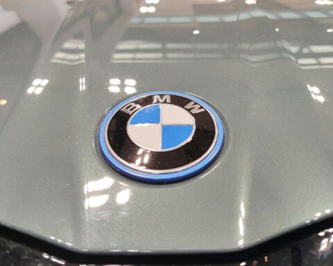 BMW-Logo am neuen BMW i5, während weltweit geplanter Stellenabbau im Konzern berichtet wird.
