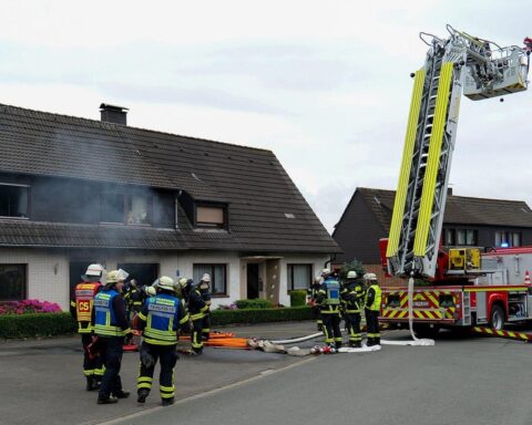 Feuerwehrleute löschen Brand in Einfamilienhaus, Bewohner evakuiert, keine Verletzten, Lithium-Akkus als Ursache.