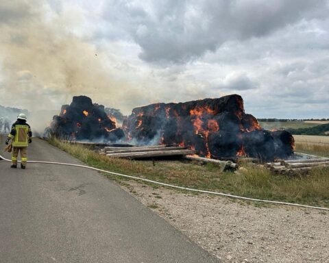Mehrere brennende Heuballen bei einem Sportplatz in Tiefenbach, Feuerwehr im Einsatz, Archivfoto.