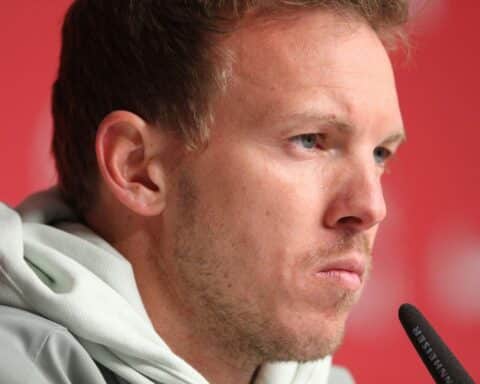 Julian Nagelsmann mit ernster Miene, symbolisiert den Rücktritt als Bundestrainer nach WM-Niederlage.