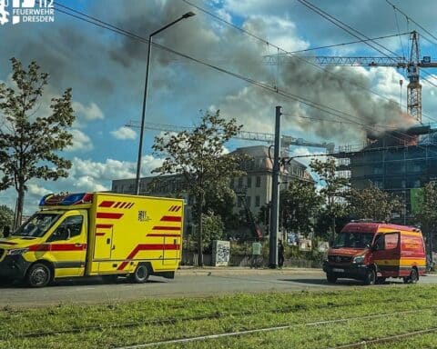 Feuerwehr im Einsatz bei Dachstuhlbrand in Dresden, Rauchentwicklung, RTW und Einsatzleitwagen vor Ort (Archiv).