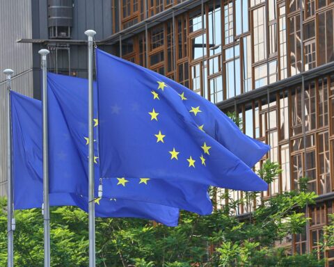 EU-Fahnen wehen, symbolisieren Förderung europäischer Unternehmen durch neue Vergaberechtsreform.