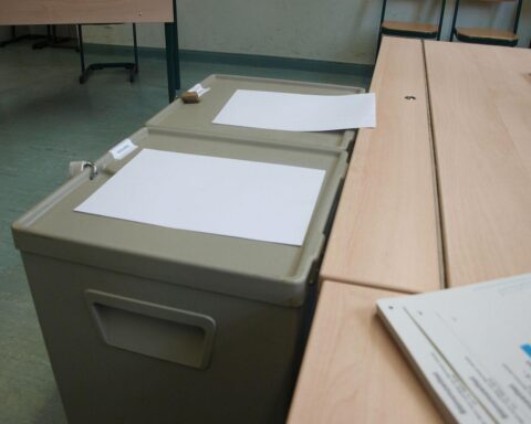 Wahllokal im Archiv: ein Wahlraum, Stimmzettel und Wahlurne – symbolisch für Bundestagswahl.