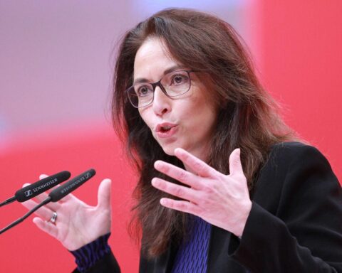 Yasmin Fahimi steht vor einer Kamera, diskutiert über Gewerkschaften und Reformen, entschlossen.