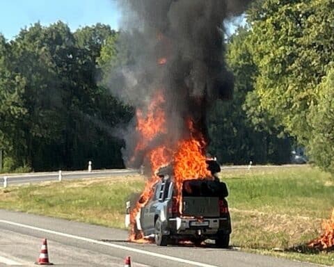 Ein brennender SUV auf der A1 bei Salmtal, Einsatzkräfte löschen Feuer neben dem Grünstreifen.