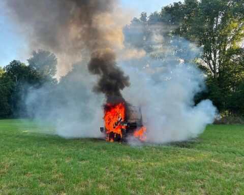 Feuerwehr Menden löscht brennende Rundballenpresse an einer Zugmaschine auf einem Feld bei Halingen.