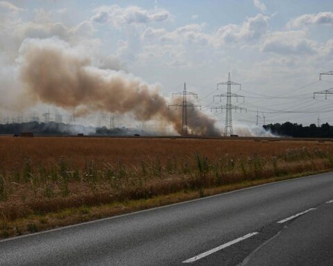 Feuerwehr bei Feldbrand in Pulheim-Sinnersdorf: Rauch über 15.000 Quadratmeter Stoppelfeld, Löscharbeiten mit Löschfahrzeugen.