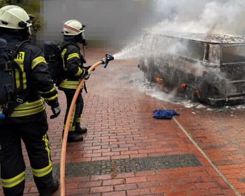 Brandbekämpfung: Feuerwehr löscht vollständig ausgebrannten VW Bulli in Debstedt. Einsatzkräfte im Einsatz.