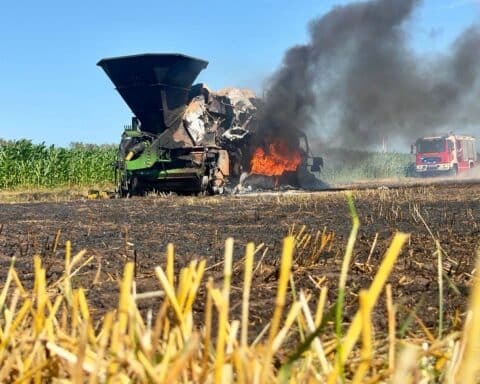 Feuerwehr im Einsatz bei Flächenbrand in Brettorf: brennende Quaderballenpresse, Rauch, Eindämmung drohender Ausbreitung.