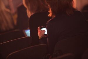 Geschäftsfrauen mit Smartphone im Archiv: weniger Frauen in Führung, lange Arbeitszeiten, Befristungen und Teilzeit.