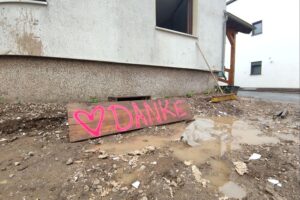 Wiederaufbau nach Hochwasser: beschädigte Infrastruktur, Baumaßnahmen, betroffene Bewohner, Hoffnung auf Fortschritt.