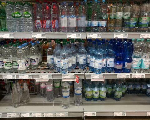 Menschen trinken aus Wasserflaschen: Rekordkäufe von stillen und Sprudelwasser während einer Hitzewelle.