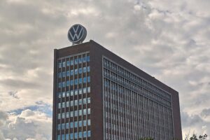 Protestierende VW-Mitarbeiter vor einem Werk, Banner gegen Sparpläne, angespanntes Arbeitsklima.