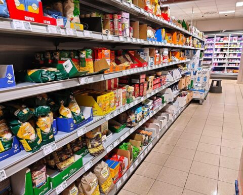 Supermarktregal mit Lebensmitteln und Preisschildern; Inflation in NRW mit Fokus auf Nahrungsmittelpreise.