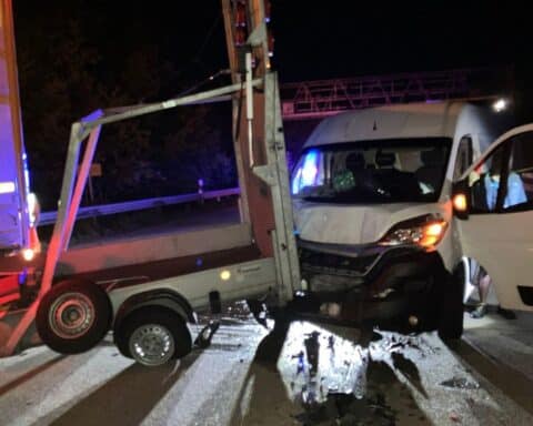 Unfallstelle mit beschädigten Fahrzeugen, blauem Transporter und Absperrbändern auf der Autobahn.