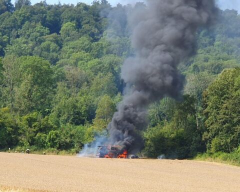 Ein Mähdrescher steht in Vollbrand auf einem Feld, Feuerwehr verhindert Ausbreitung, Polizei ermittelt.