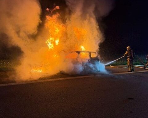 Ein brennendes Auto auf der Autobahn, Feuerwehr im Einsatz, dramatische Rettungsszene.