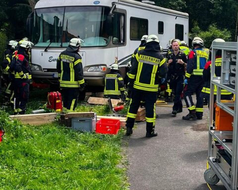 Feuerwehr rettet eingeklemmte Person unter Wohnmobil mit Hebekissen und medizinischer Versorgung.