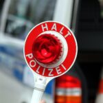Halt-Stopp-Schild der Polizei bei Verkehrskontrolle in Stendal (Archiv), mit kontrollierenden Beamten.