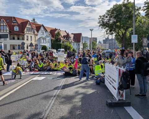 Demonstranten protestieren friedlich vor AfD-Parteitag, Polizeipräsenz und Sicherheitsmaßnahmen sichtbar.