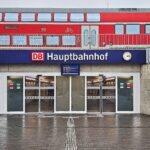 Regionalzug am Hauptbahnhof, umgeben von Menschen, symbolisiert Sicherheit und Alkoholverbote im Bahnverkehr.