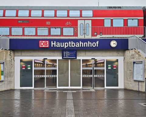 Regionalzug am Hauptbahnhof, umgeben von Menschen, symbolisiert Sicherheit und Alkoholverbote im Bahnverkehr.