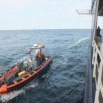 Nahaufnahme: Bundespolizeikontrollboot zieht geborgenes Rotorblatt aus der Nordsee, später an Bord zersägt.