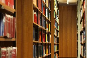 Professor hält wissenschaftsfreiheit-bezogene Rede; im Hintergrund Bücher in einer Bibliothek (Archiv) bei Saarbrücken.