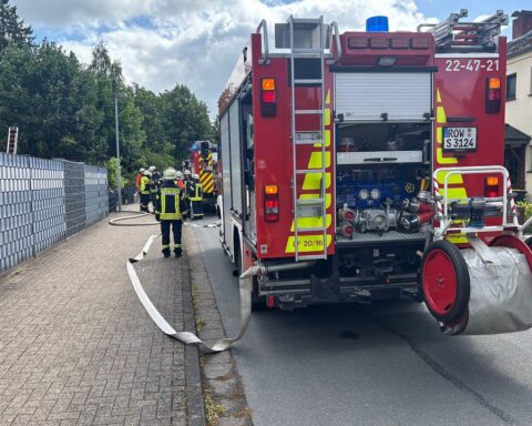 Feuerwehr im Einsatz zur Brandbekämpfung in einem Schuppen, Wärmebildkamera zur Kontrolle eingesetzt.