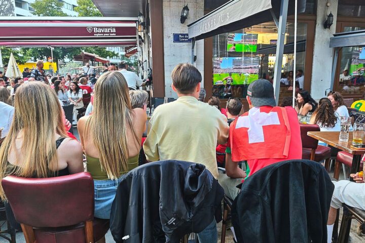 Fußballfans in einer Bar genießen das spannende Elfmeterschießen zwischen Schweiz und Kolumbien.