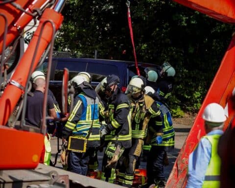Bauarbeiter wird aus Baugrube gerettet, Feuerwehr und Rettungsdienst im Einsatz.