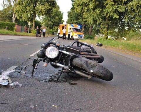 Verunfalltes Motorrad und beschädigtes Auto nach schwerem Verkehrsunfall auf Bundesstraße 230.