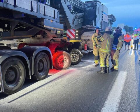 Einsatzkräfte löschen Brand an Schwertransporter, Feuerwehr kontrolliert mit Wärmebildkamera am Autobahnkreuz.