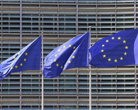 EU-Fahnen vor Hintergrund kritischer Rohstoffe: Versorgungssicherheit droht wegen Importabhängigkeit, Studie warnt.