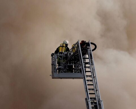 Feuerwehr auf Drehleiter (Archiv), im Hintergrund Waldbrandgefahr durch Klimawandel in Frankreich und Spanien.