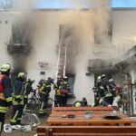 Feuerwehr Dortmund löscht Wohnungsbrand: dichter schwarzer Rauch aus Fenstern eines Hinterhofgebäudes (Archiv).