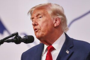 Donald Trump (Archiv) vor Hintergrund von Kriegsschauplatz Iran, Schiffsschäden und Hafenanlagen.