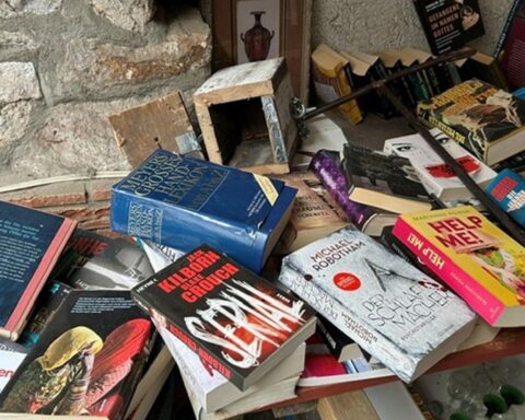 Beschädigte Vertrauenskasse im Hof, zwischen Büchertisch und Pflaster, Polizei ermittelt.