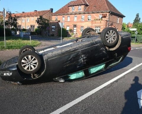 Zwei verunfallte Autos in Salzwedel: VW liegt nach Kollision auf dem Dach, Polizei auf Unfallstelle.