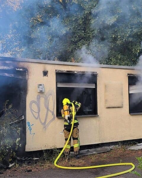 Vereinsheim in Oberhausen-Alstaden steht im Vollbrand, Feuerwehr und Polizei im Einsatz, Straße gesperrt.