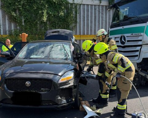Verkehrsunfall auf Autobahn, Einsatzkräfte helfen verletzter Person, Lkw und Pkw kollidiert.
